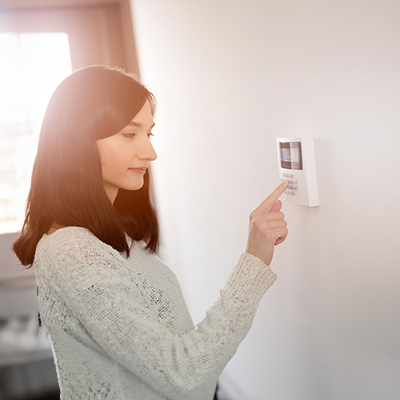 woman entering code into her intruder alarm panel