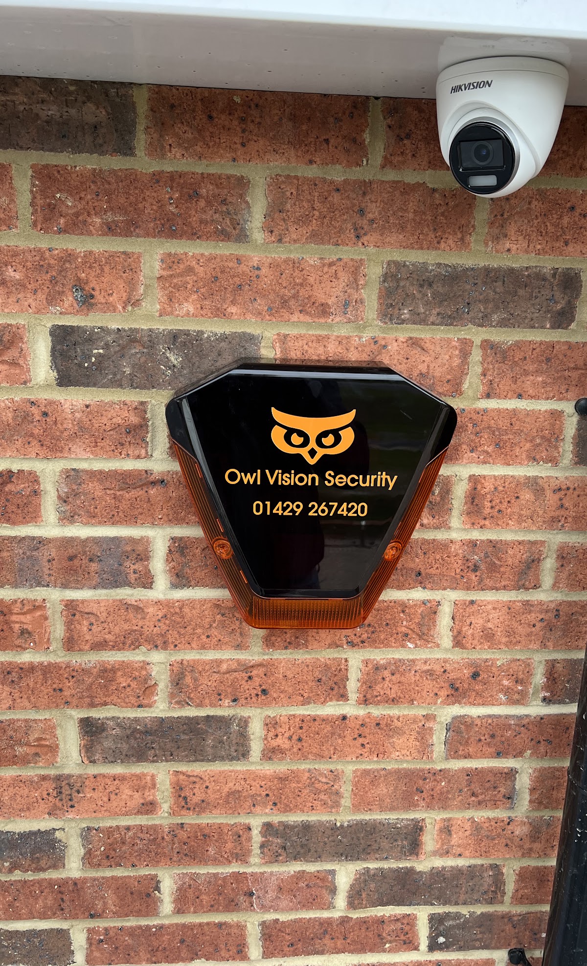 Technician installing a CCTV camera on a wall